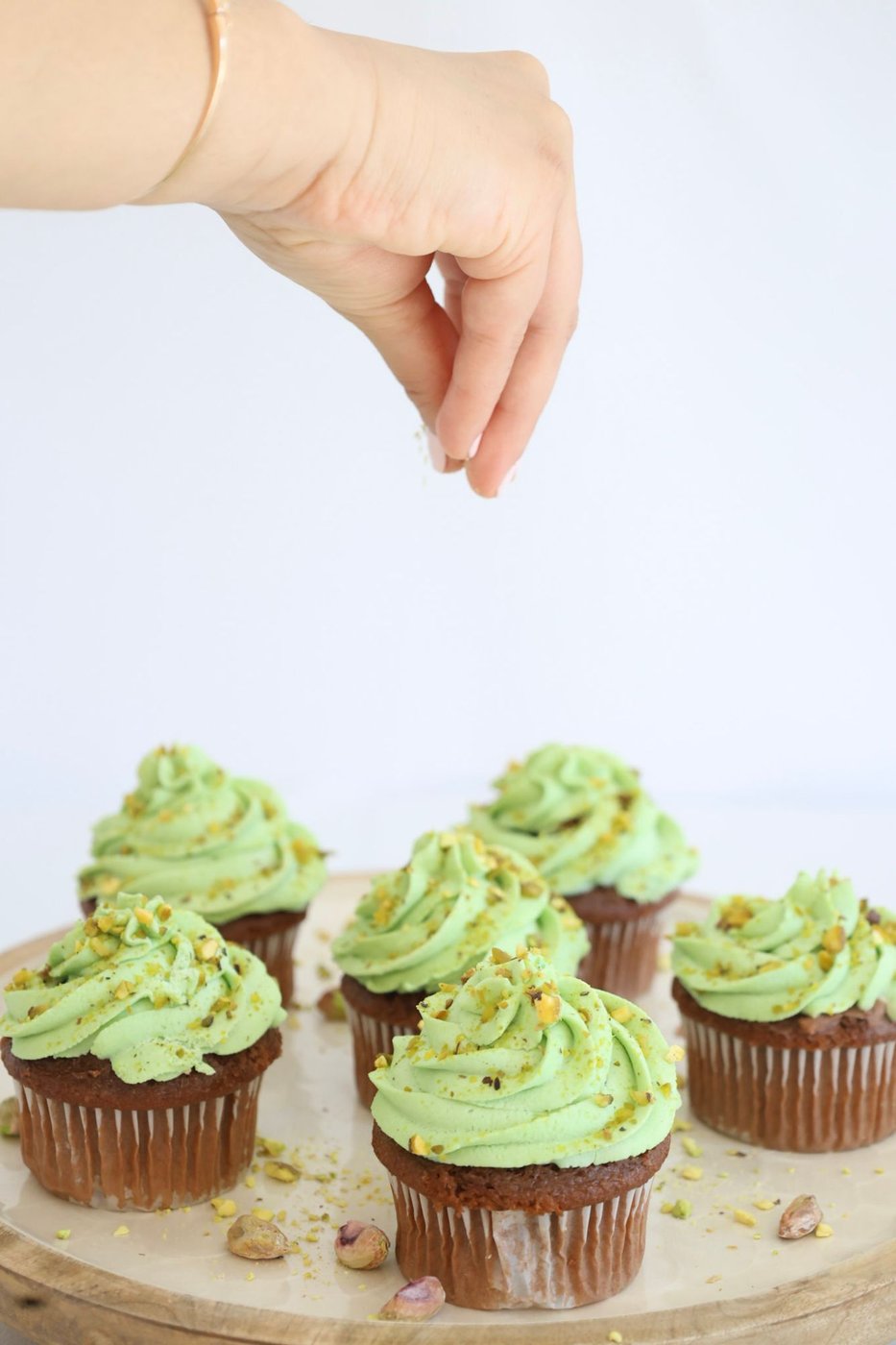 Pistachio cupcakes with green whipped icing, finished with a hand sprinkling crushed pistachio