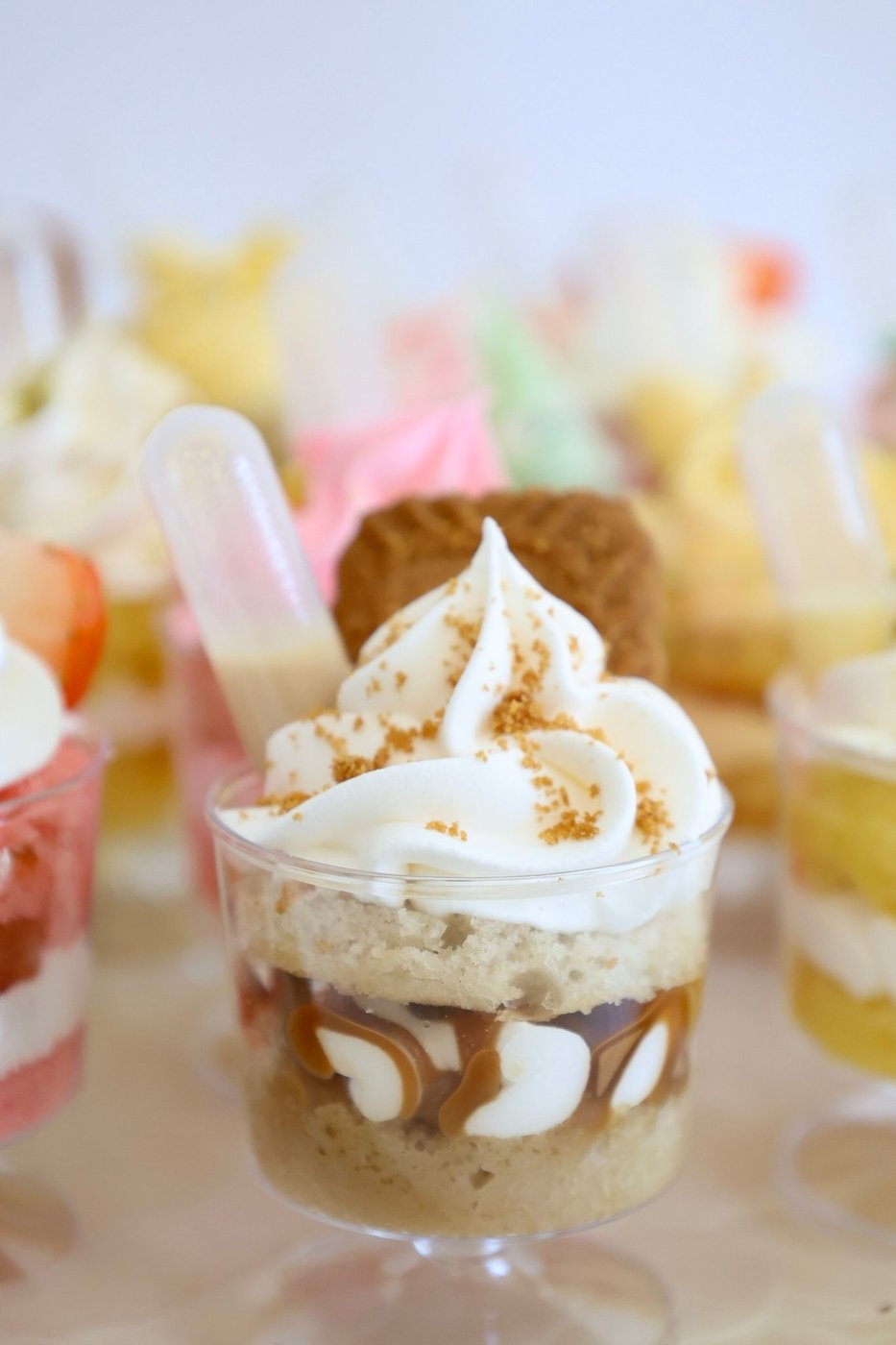 Close-up of a Biscoff caramel dessert cup topped with whipped cream and a Lotus cookie